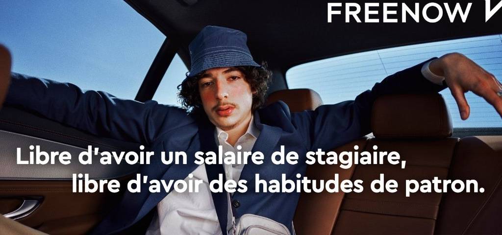 Jeune homme dans un VTC, avec le message suivant : Libre d'avoir un salaire de stagiaire, libre d'avoir des habitudes de patron
