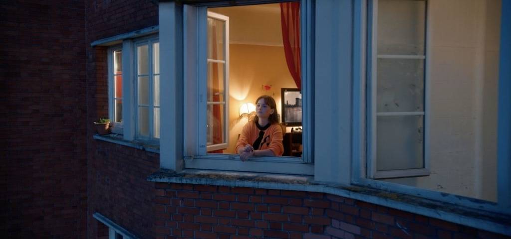 Jeune fille regardant par la fenêtre