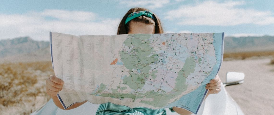 Carbo, la greentech française qui aide les citoyens à comprendre et réduire leur impact carbone, dévoile la première carte interactive de France estimant l'empreinte carbone des Français à l’échelle régionale Jeune femme assisie sur le vapot d'une voiture regardant une carte