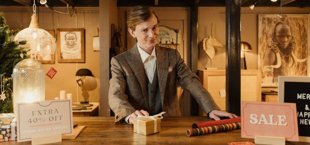 Homme deriirère un comptoir de boutique