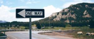 Un panneau "one way" devant une montagne