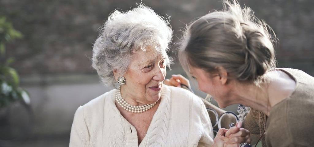 Femme tenant la main d'une personne âgée