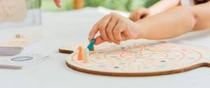 Enfant déplaçant un pion sur un plateau de jeu en bois