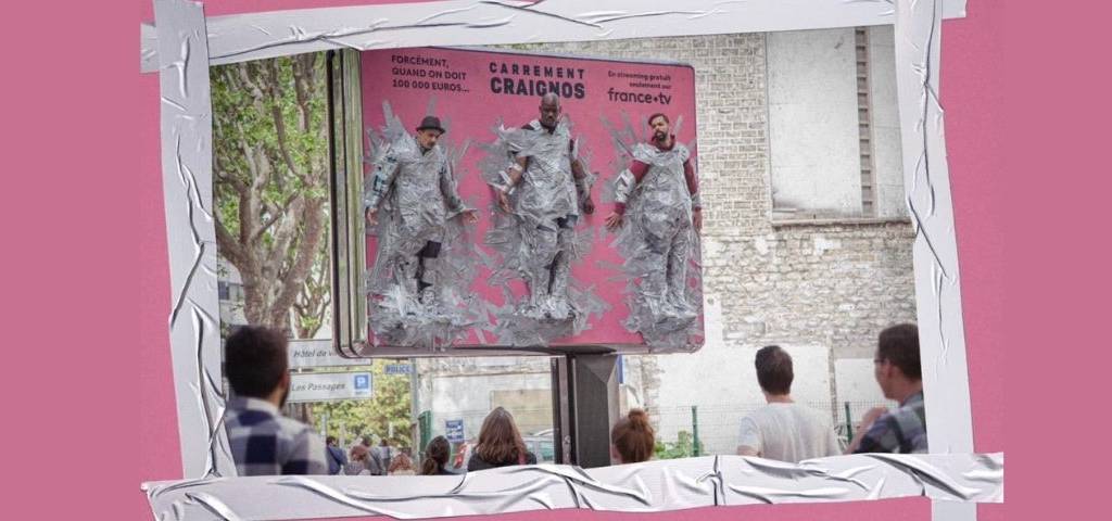 Des hommes scotchés à un panneau publicitaire (humour)