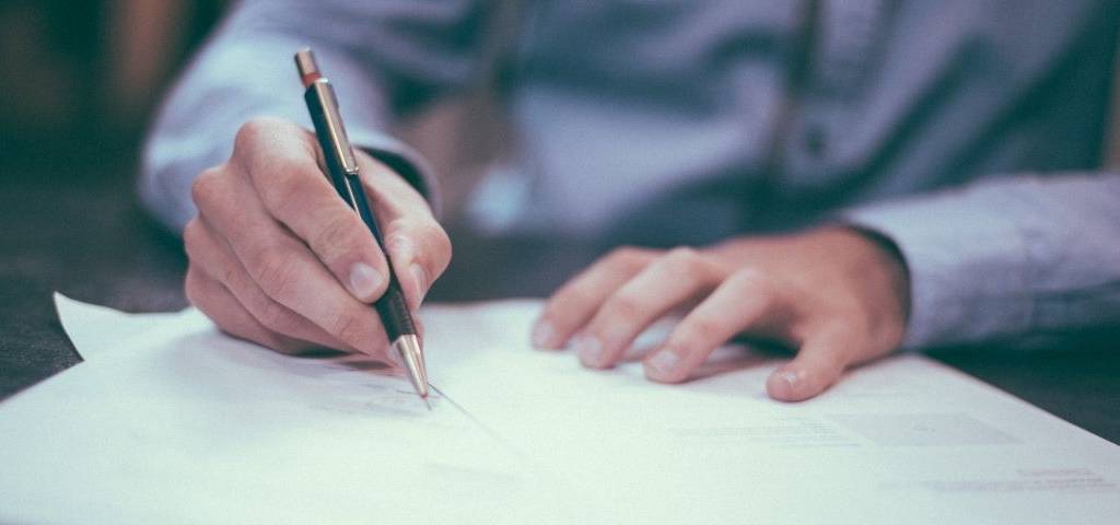 un homme signe un papier