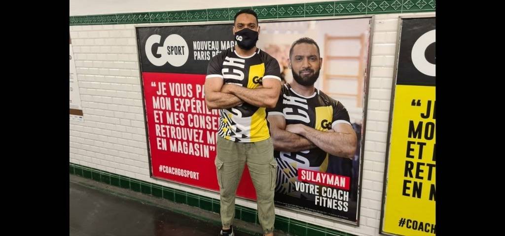 Un homme devant une campagne de communication affichée dans les métros parisiens.