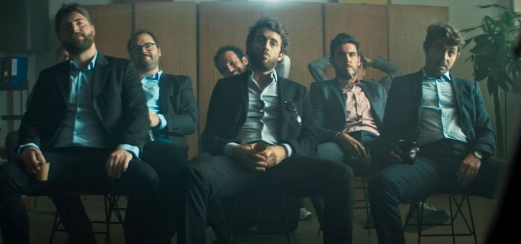 Hommes assis dans une salle en costume