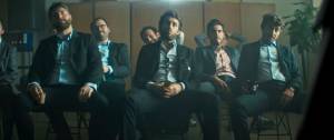 Hommes assis dans une salle en costume