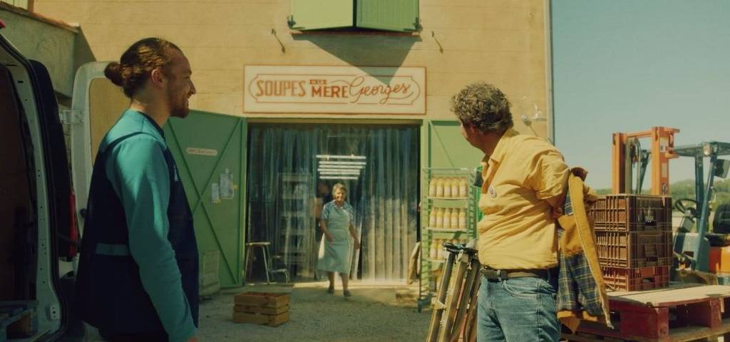 Femme sortant de sa boutique avec 2 hommes devant