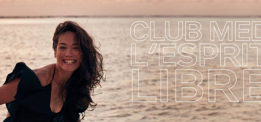 Touché signe en réponse la nouvelle campagne de marque monde qui apporte un nouveau souffle de liberté et élève “L'esprit libre” en étendard de la promesse de marque. femme souriante avec la mer au second plan