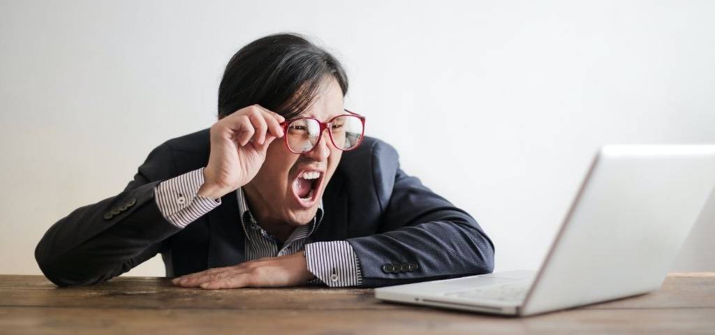 Homme en colère devant un ordinateur