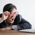 Homme en colère devant un ordinateur