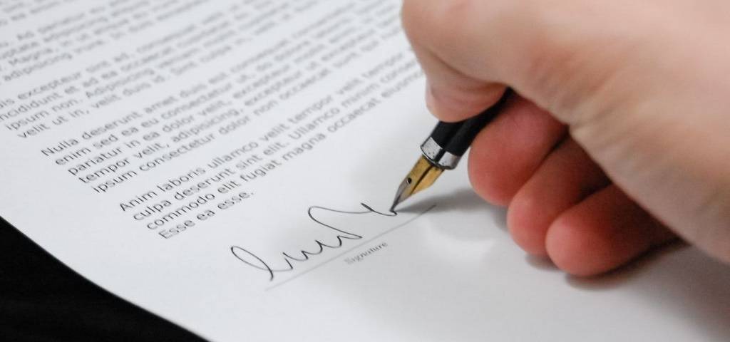 Main signant une feuille