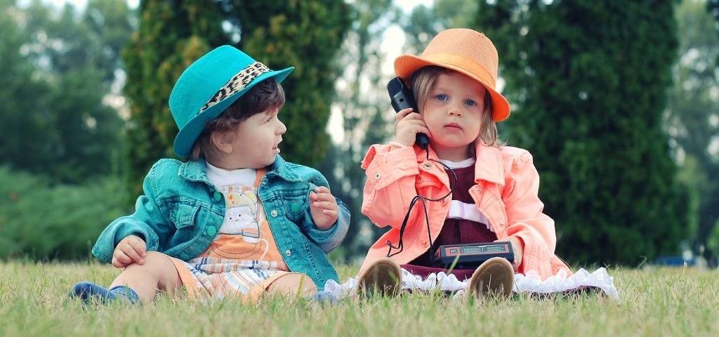 2 enfants assis dans l'herbe
