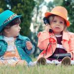2 enfants assis dans l'herbe
