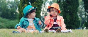 2 enfants assis dans l'herbe
