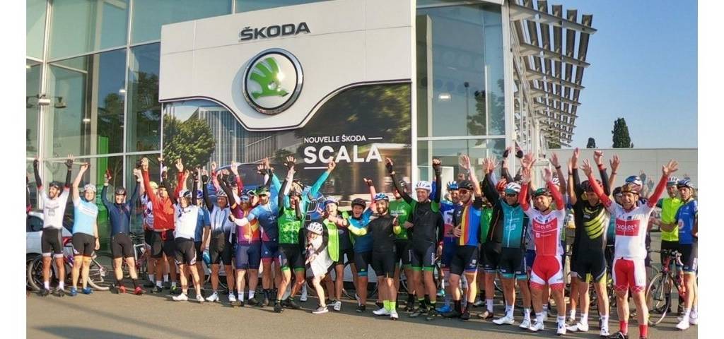 Une team de cyclistes devant l'enseigne Skoda