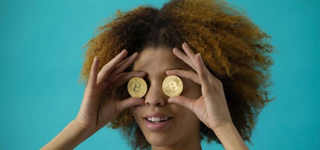 Jeunes femmes avec deux pièces de monnaie devant les yeux