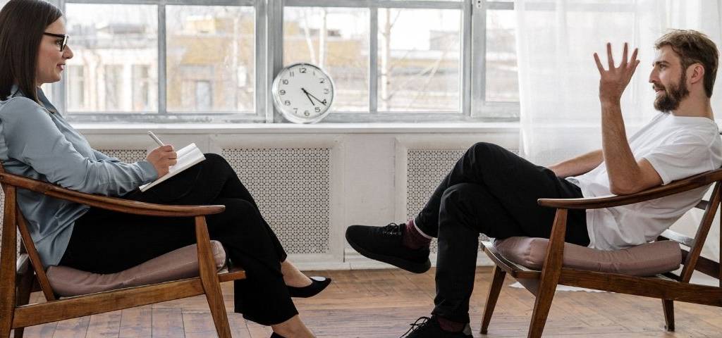 une femme et un homme assis face à face