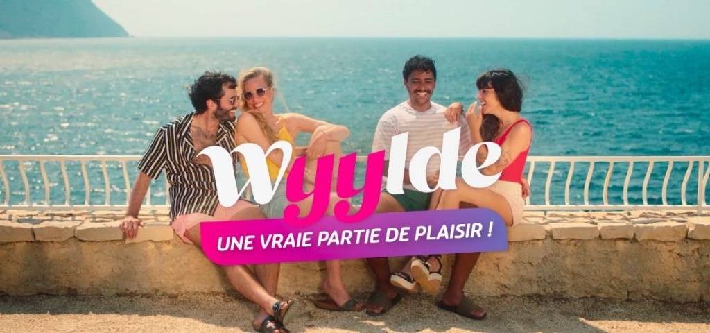 2 couples assis sur un muret avec la mer dans le dos