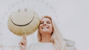 Femme sourian avec un ballon en forme de smiley