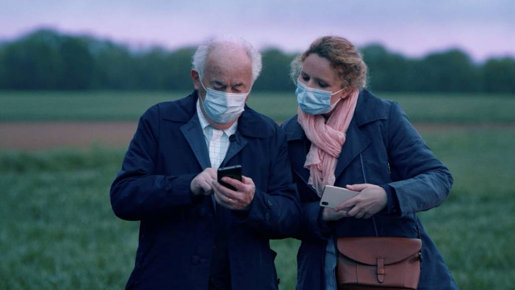 Personne âgée avec un smartphone accompagnée d'une femme