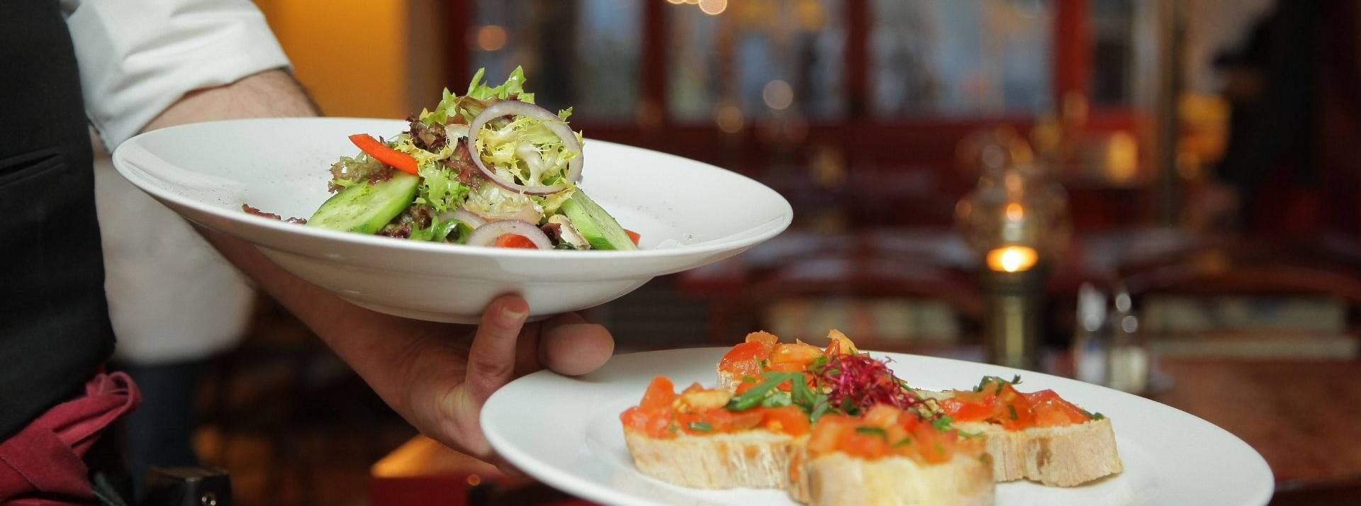 Ethi’Kdo étend son activité de bons cadeaux à la restauration en reprenant Kadoresto, grâce à une première opération de croissance externe. Serveur avec 2 assiettes dans la main