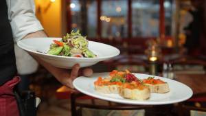 Serveur avec 2 assiettes dans la main