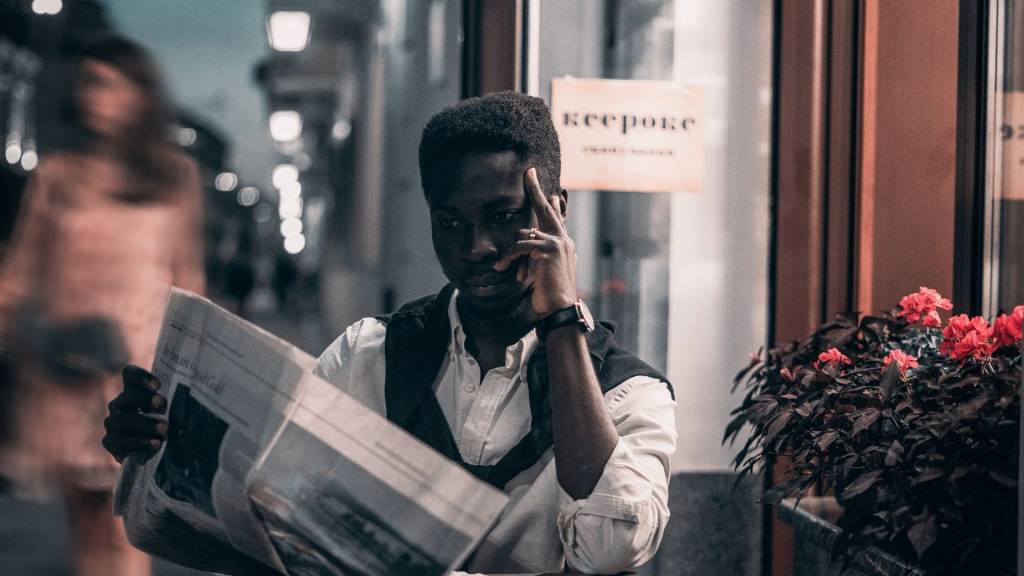 Homme lisant un journal dans un bar