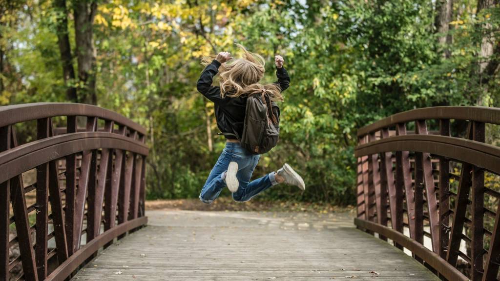Jeune fille de dos sautantde joie