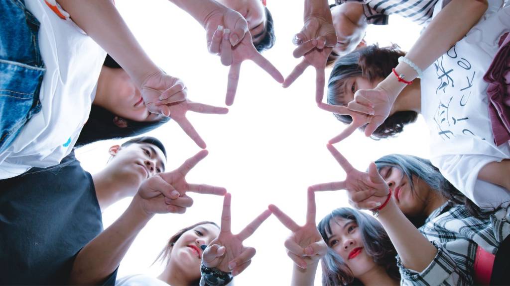 Groupe de personnes formant une étoile à l'aide de leurs mains