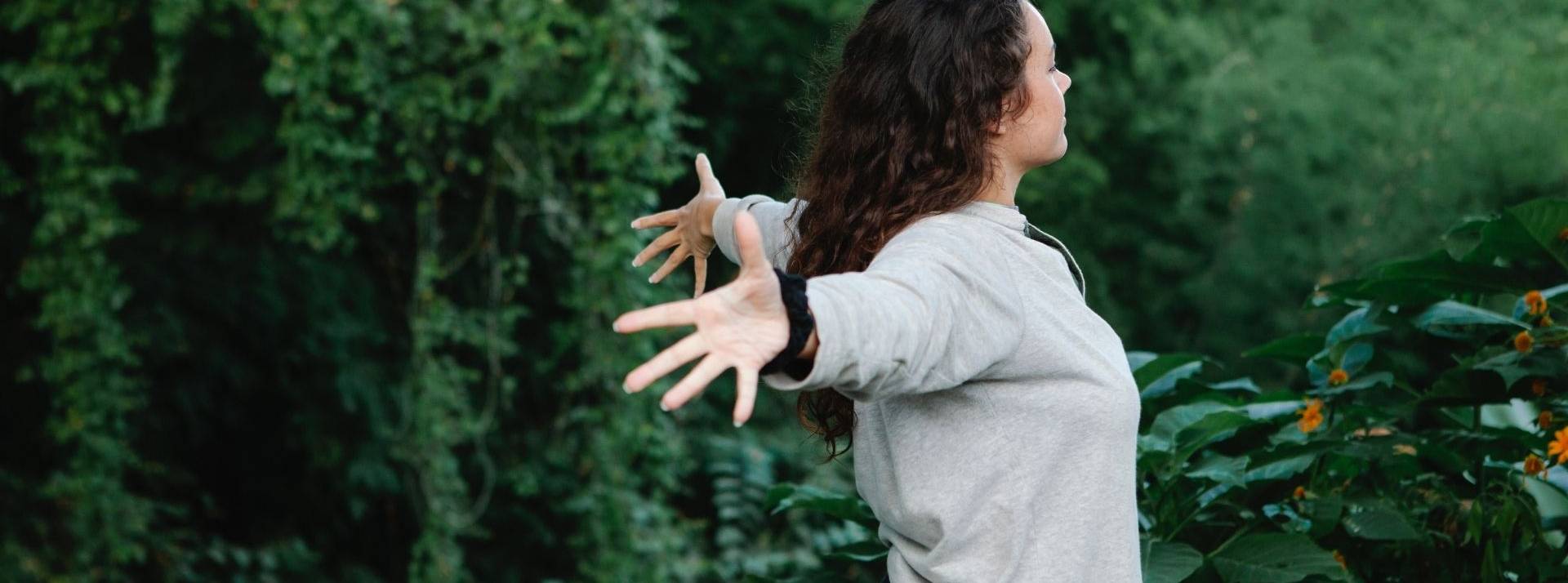 Semaine européenne verte du développement durable : Tour d’horizon d'initiatives fortes et impactantes Jeune femme écratrant les bras entourée d'arbre