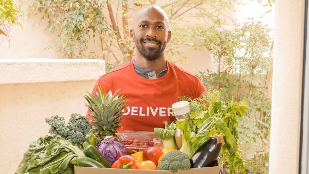 Homme livrant un panier de légumes