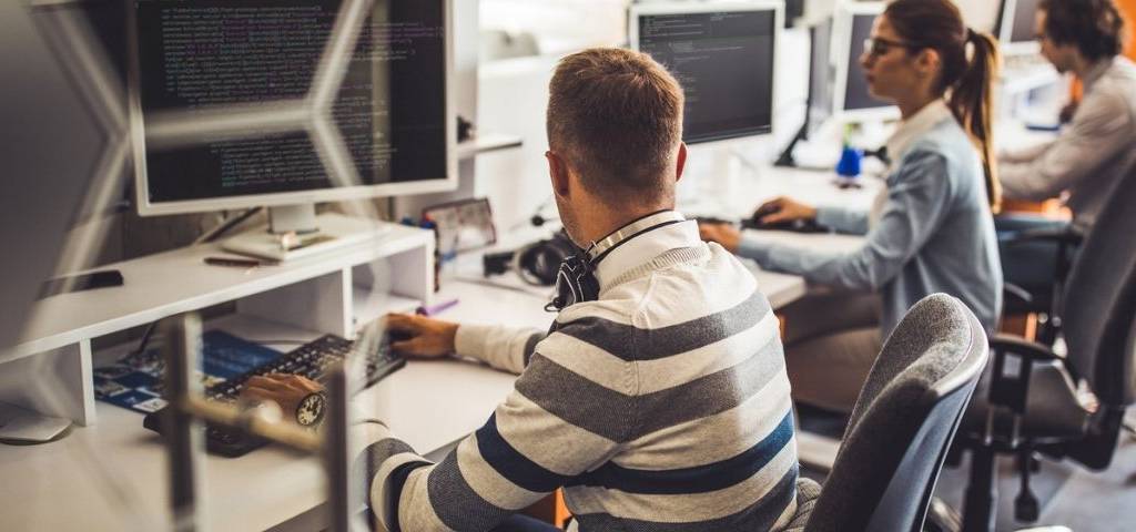 Groupe de programmeurs travaillant sur PC dans le bureau.