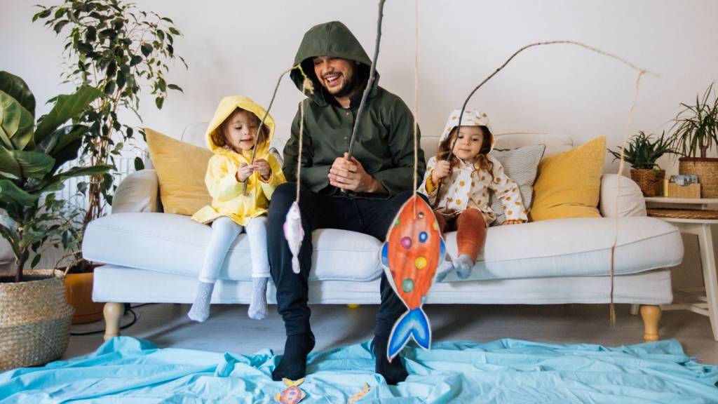 Enfnats avec le père jouant la pêche à la maison