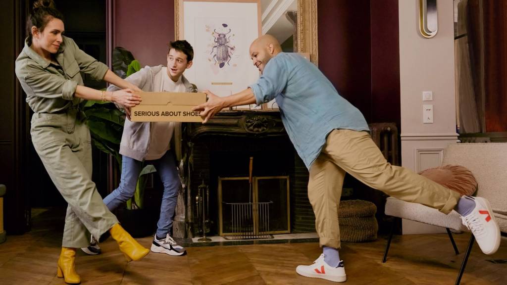 Un homme, une femme et un adolescent tenant un carton Sarenza