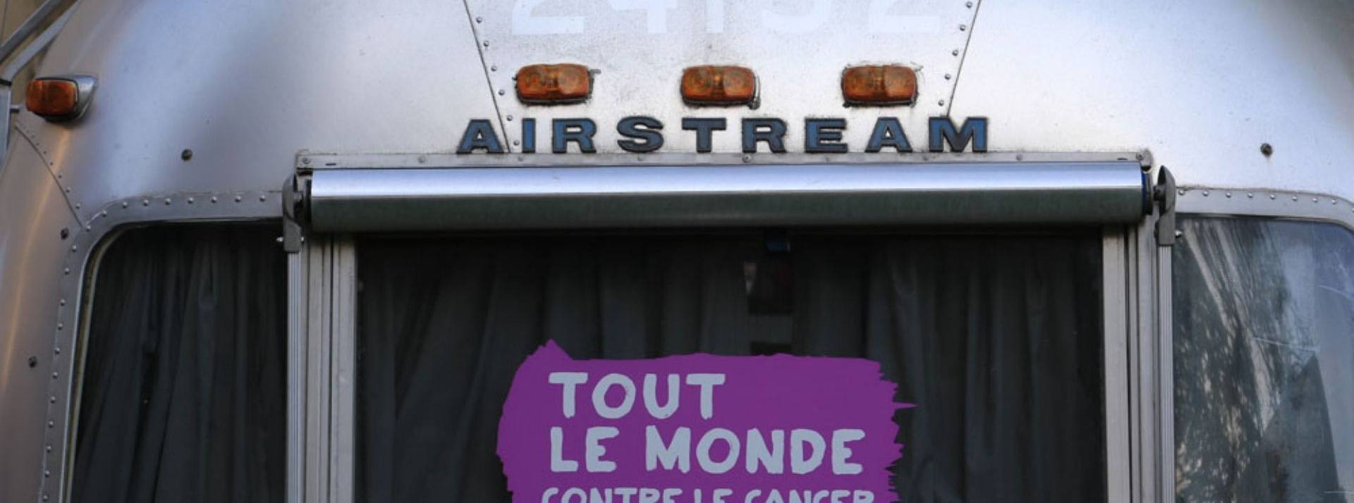 Cheerz s’engage tout au long d’octobre rose auprès de l’association tout le monde contre le cancer Camionnette avec une pancarte à l'arrière - Tout le monde contre le cancer -