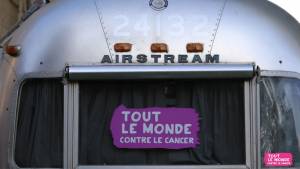 Camionnette avec une pancarte à l'arrière "Tout le monde contre le cancer"