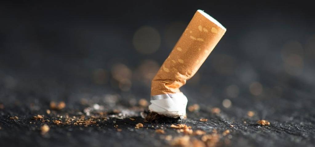 Mégot de cigarette écrasée sur le sol.