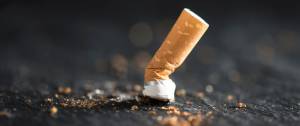 Mégot de cigarette écrasée sur le sol.