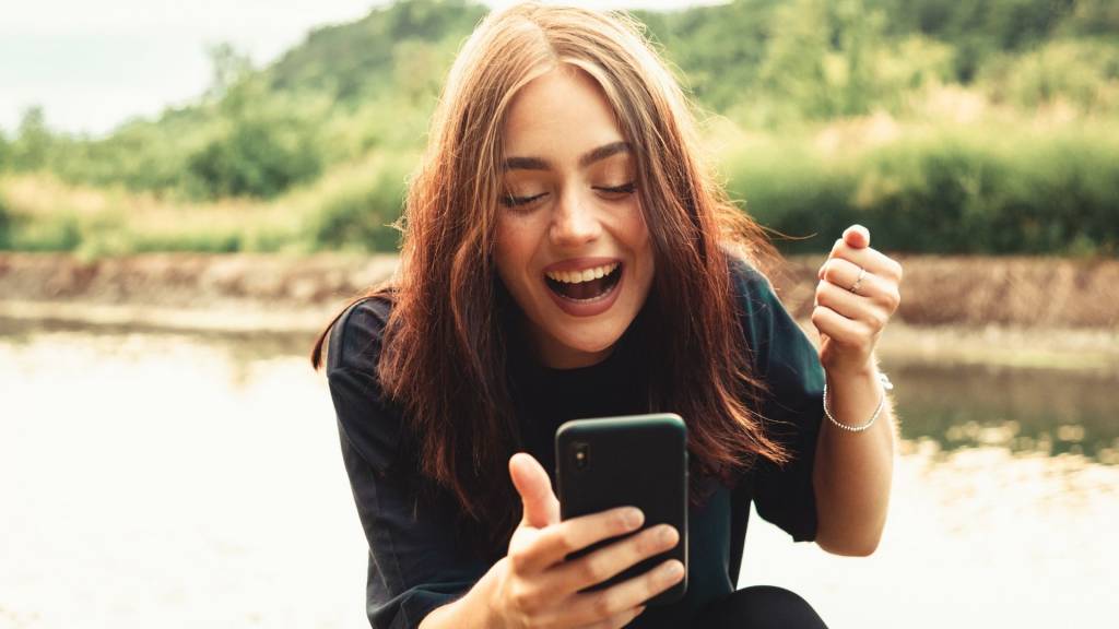 jeune femme joyeuse devant son smartphone