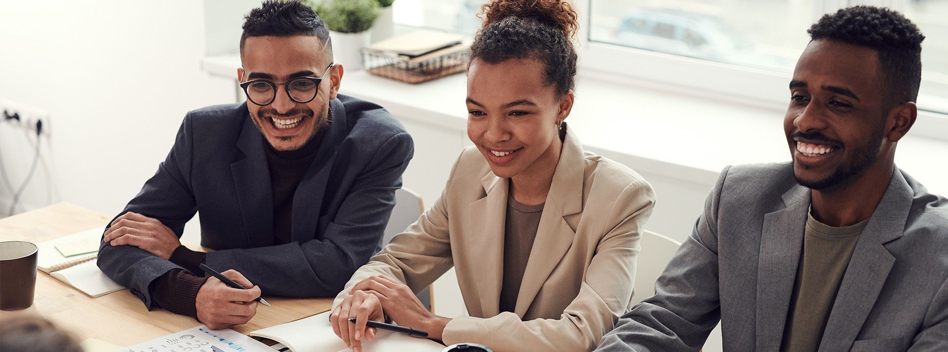 Selon une étude IWG : 78,5 % des professionnels français se sentent plus épanouis depuis qu’ils travaillent de manière flexible 2 hommes et une femme souriant au travail