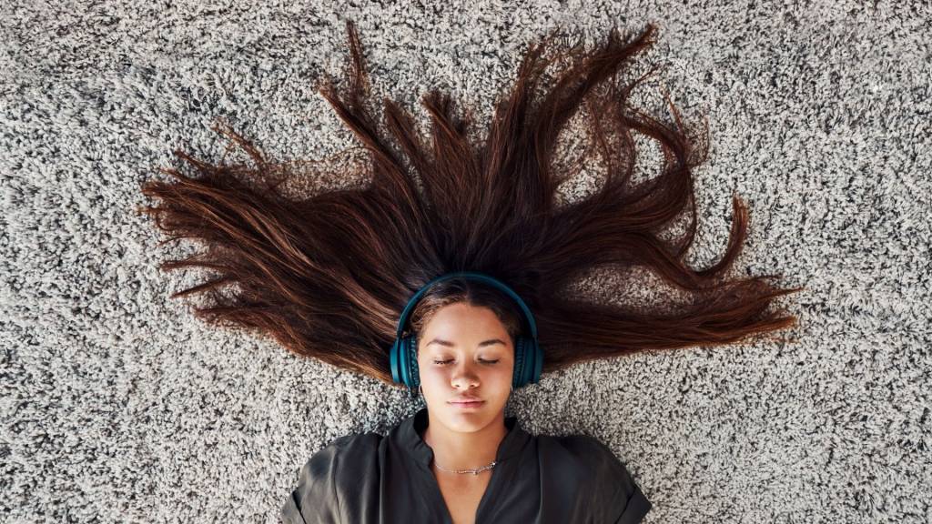 femme allongée sur de la moquette écoutant de la musique