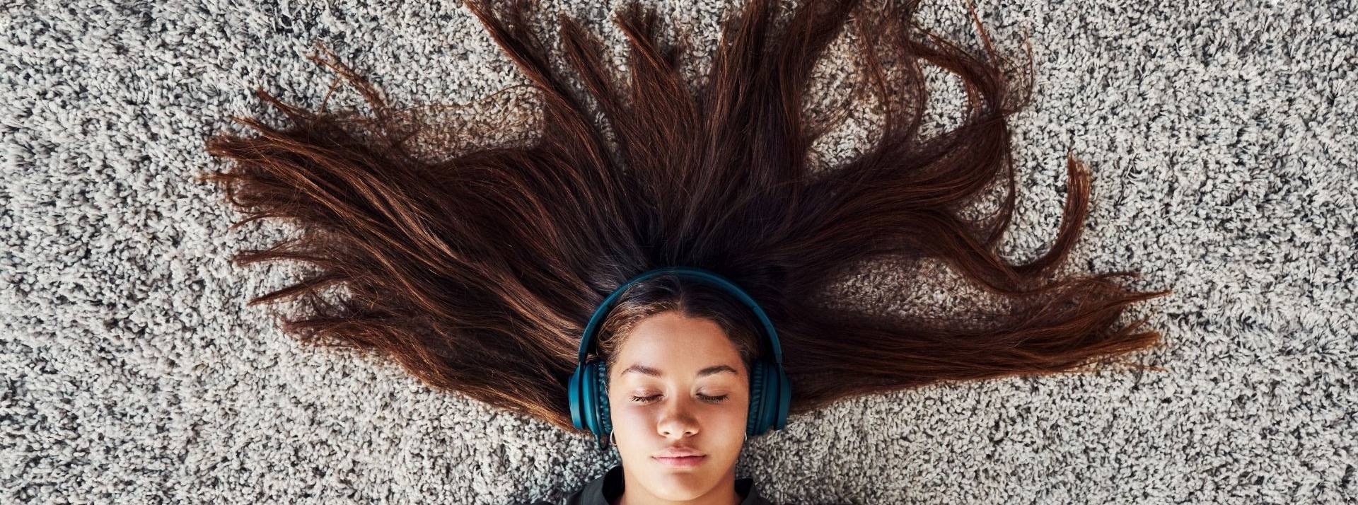 Interface obtient une validation scientifique indépendante de son objectif de réduction d’émissions de GES femme allongée sur de la moquette écoutant de la musique