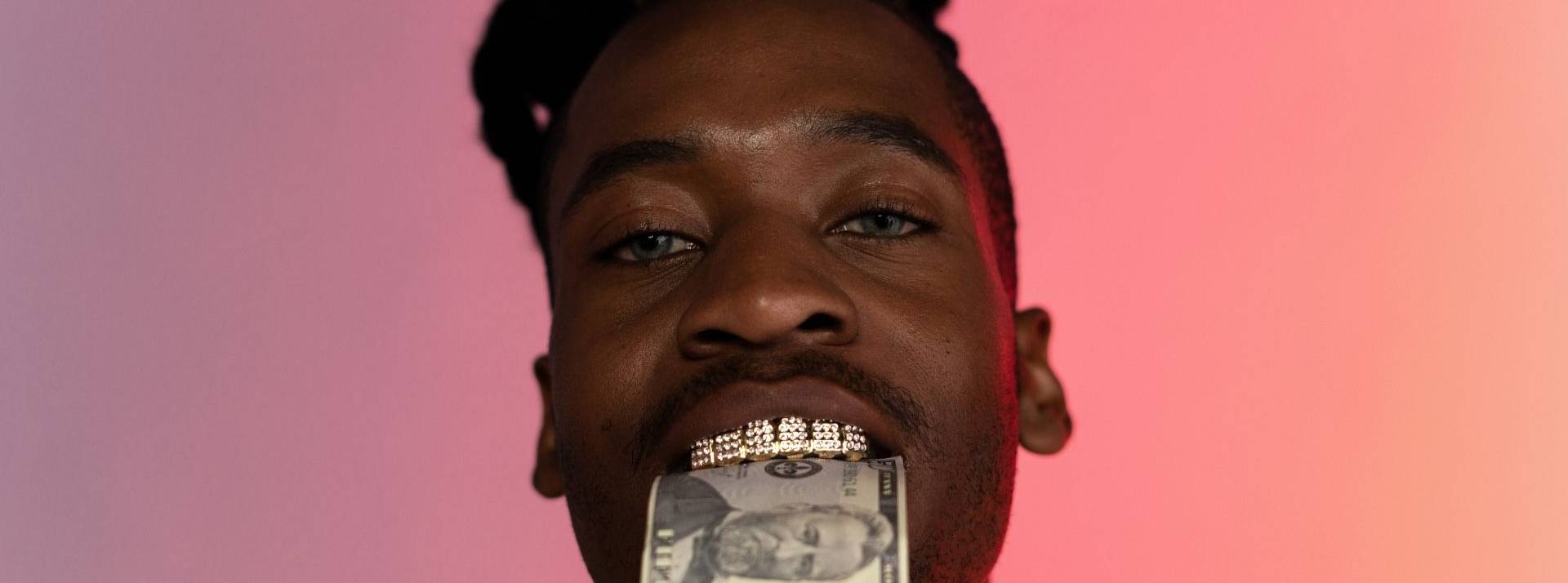 Roxanne, une agence qui bouscule les codes en connectant le rap et les marques Rappeur avec des dents en argen et un billet dans entre ses dents