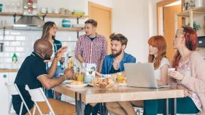 Groupe de personnes prenant le petit déjeuner autours d'une table dans un appartement