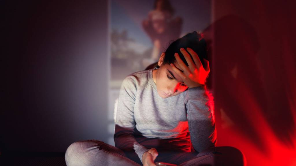 Jeune femme se tenant la t^te devant son smartphone