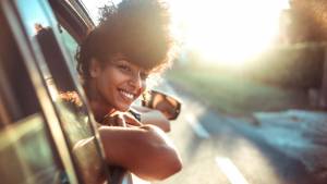 Femme sortant sa tête par la vitre d'une voiture
