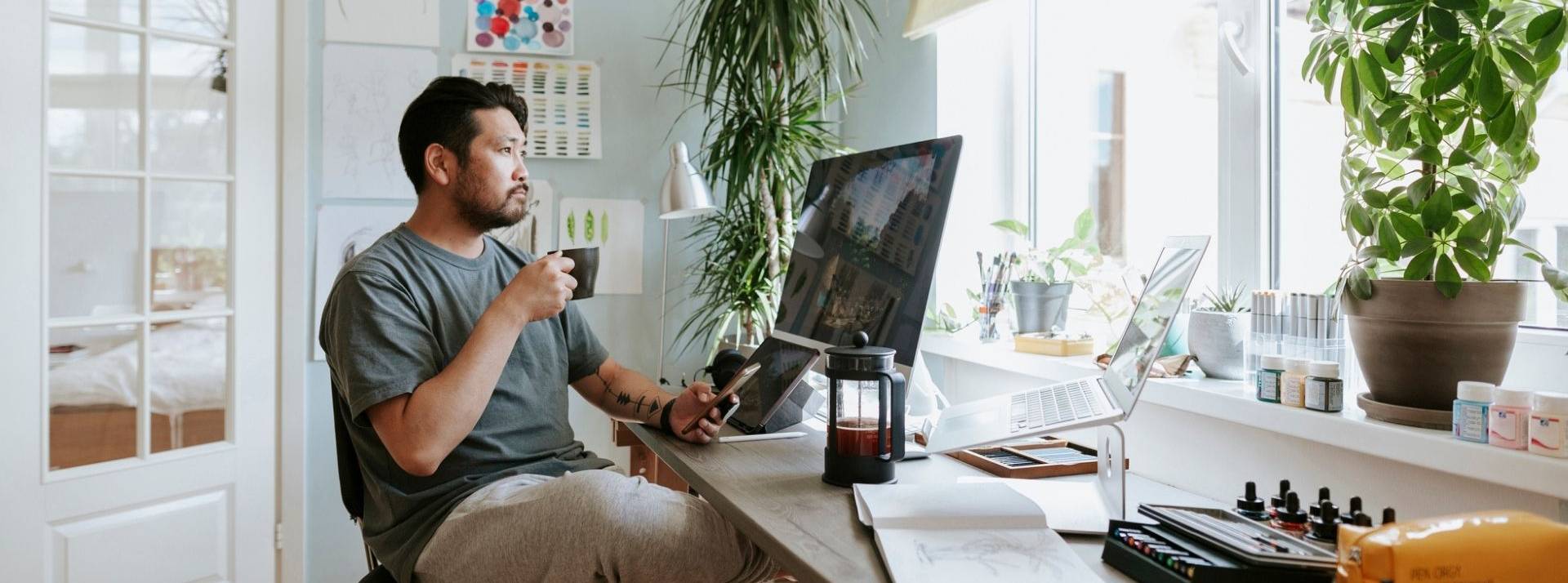 Comment assurer la productivité de vos équipes dans un monde du travail décentralisé ? Un homme assis devant son ordinateur