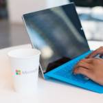Une personne travaillant à son bureau avec un verre Microsoft.